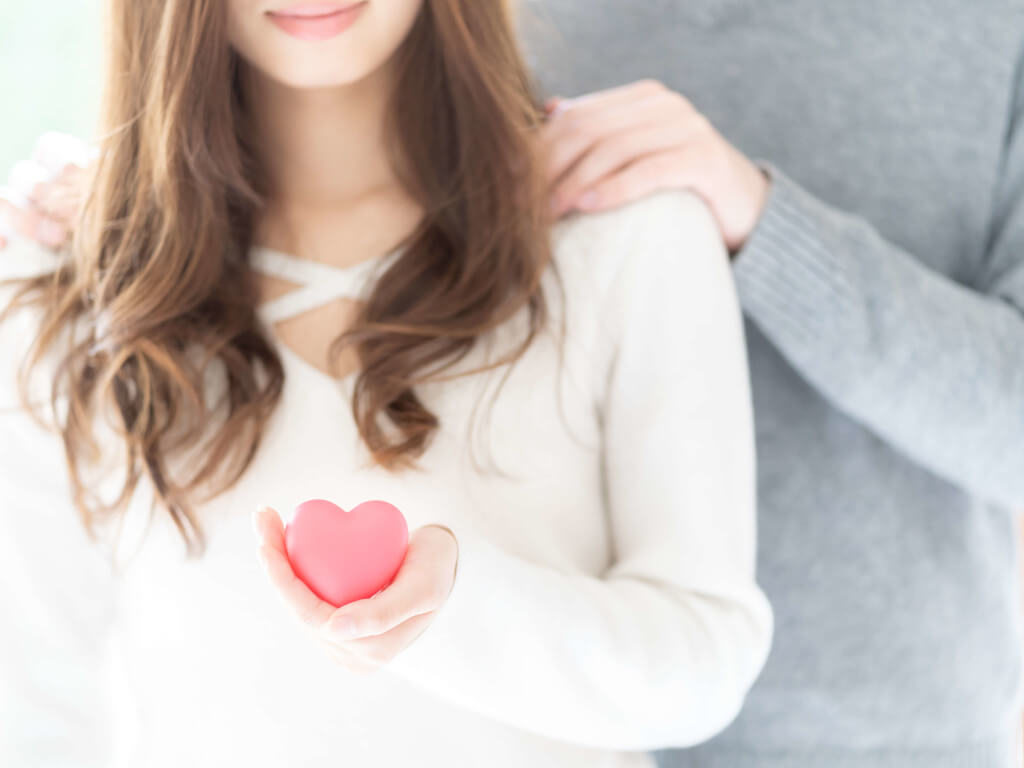 ピンクのハートを持つ女性